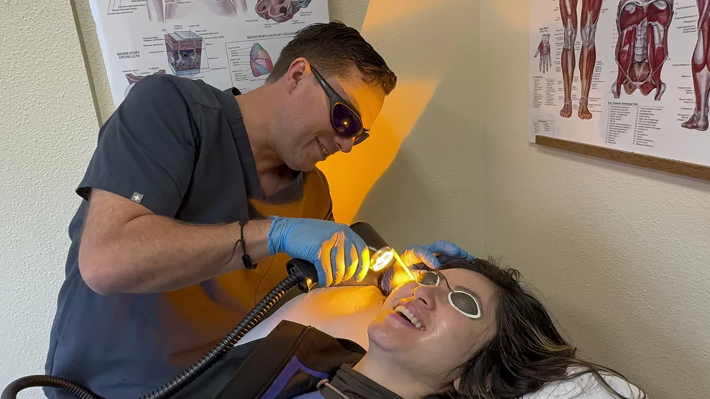 Dr. Andrew Simon performing AdvaTx laser therapy on a patient